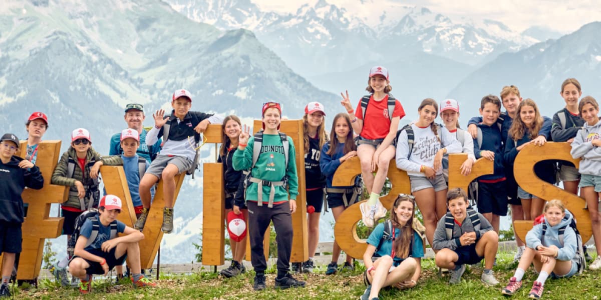 スイスの丘の上で、Villasというオブジェの前で写真に写る子供たち