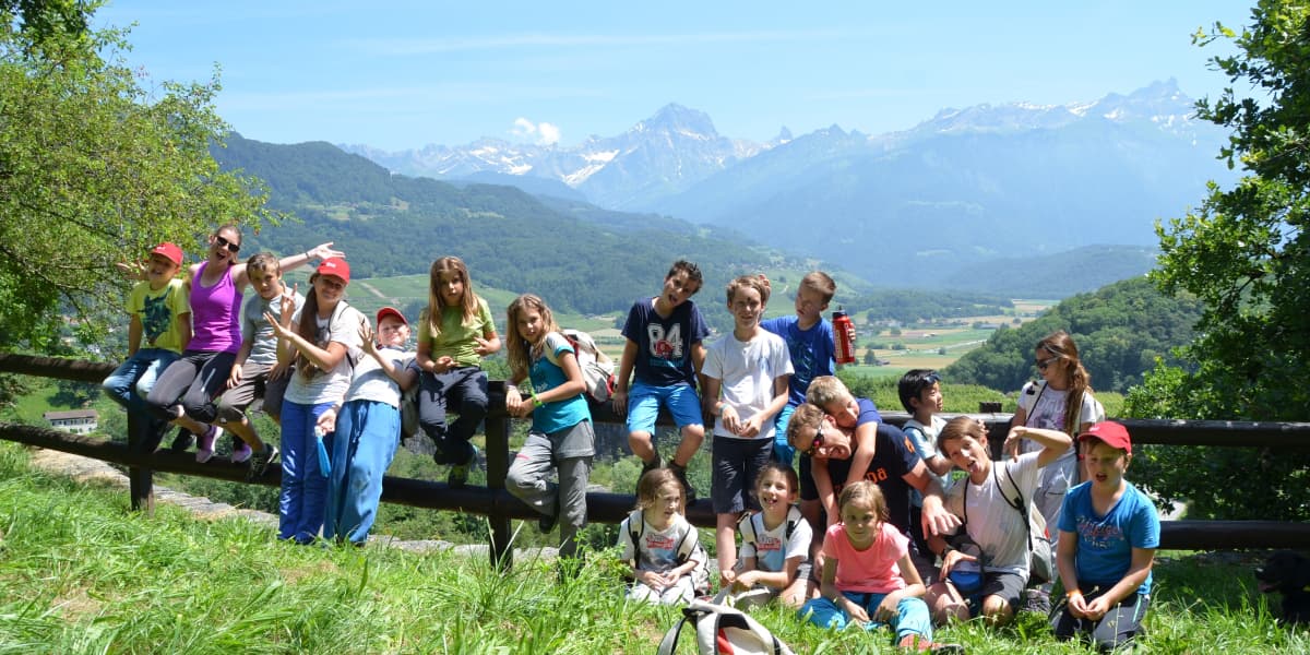 自然の中で木製の柵に寄りかかって写真に写る子供たち